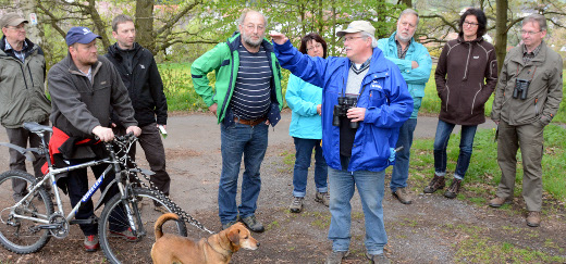 Heinz-Günther Schneider (mit Fernglas) erklärt den Teilnehmern den Verlauf der Wanderung.